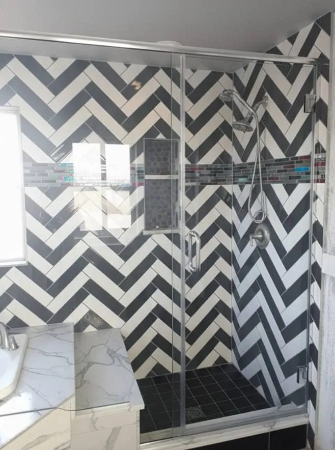 black-and-white herringbone tile shower with glass enclosure